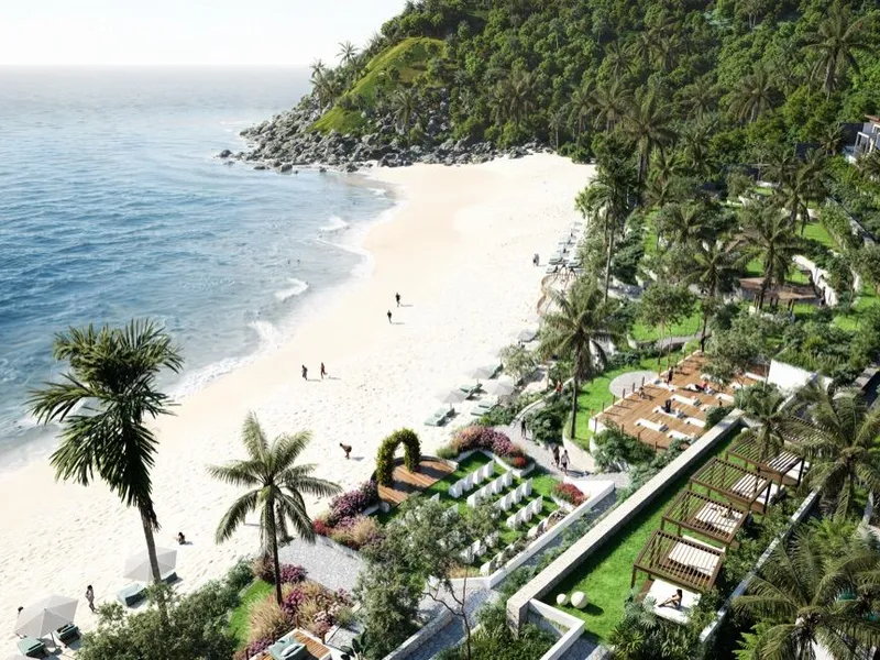 An aerial render of The One Lombok: a white-sand beach curving to a rocky, forested headland, with palm-lined gardens, pergola day beds and white villas stepping up the hillside beside it.