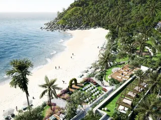 An aerial render of The One Lombok: a white-sand beach curving to a rocky, forested headland, with palm-lined gardens, pergola day beds and white villas stepping up the hillside beside it.